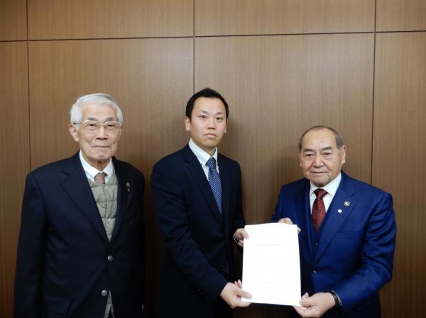 長﨑市長に対し、小野田代表監査委員と尾川監査委員が報告書を提出している写真